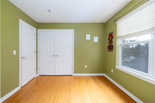 a view of a room with wooden floor and a window