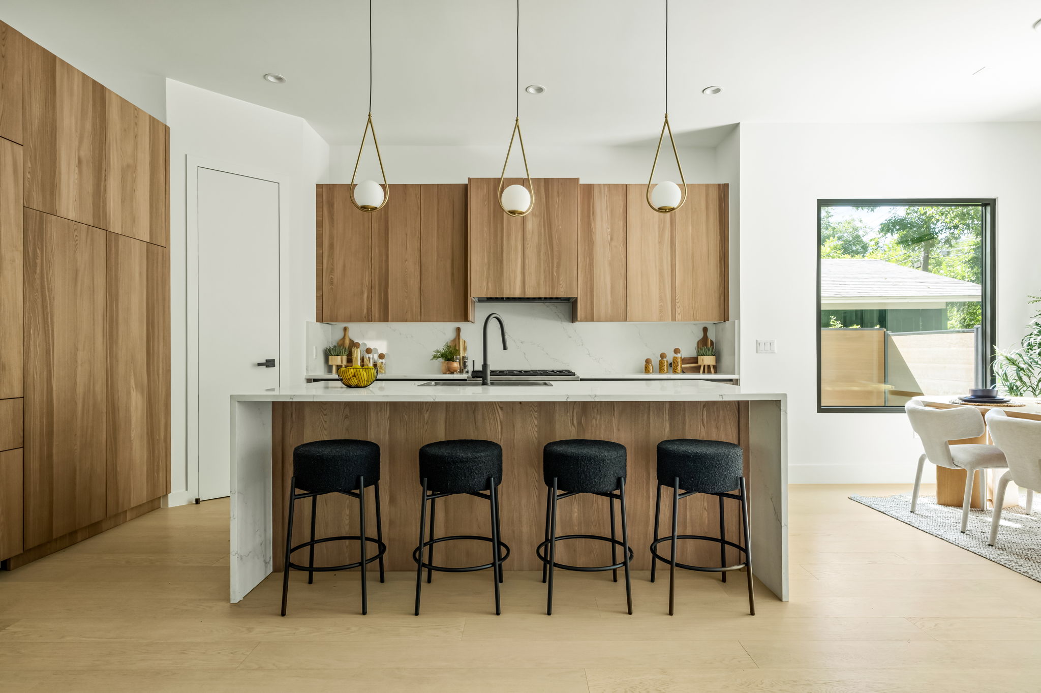 3210 Thompson Street Austin, TX 78702 - Photo 6 of 39 A modern kitchen presents an inviting island with pendant lighting and integrated wooden cabinetry.