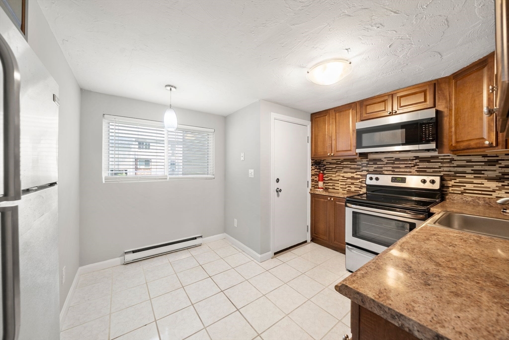 9 Tideview Path, Unit 10 Plymouth, MA 02360 - Photo 2 of 9 a kitchen with granite countertop a stove cabinets and microwave