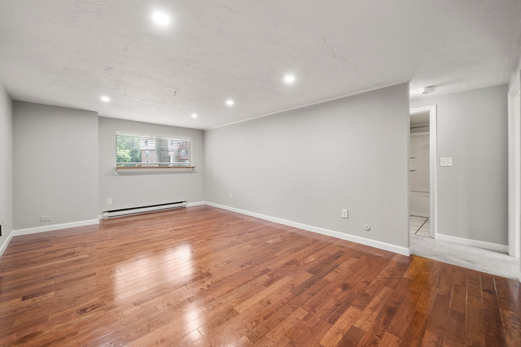 9 Tideview Path, Unit 10 Plymouth, MA 02360 - Photo 4 of 9 an empty room with wooden floor and windows