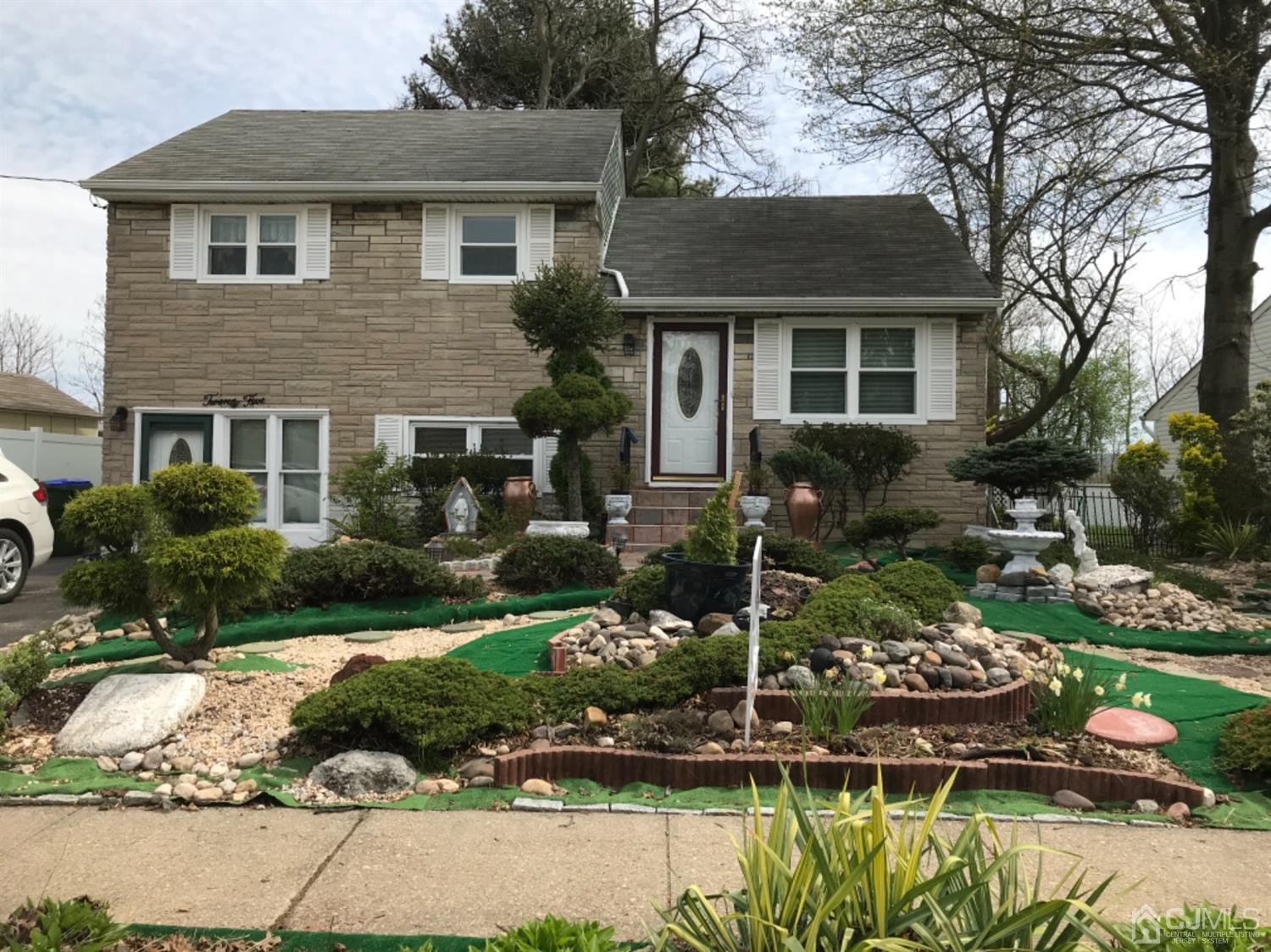 25 Wilshire Road Edison, NJ 08817 - Photo 1 of 18 a front view of a house with a yard and a large tree