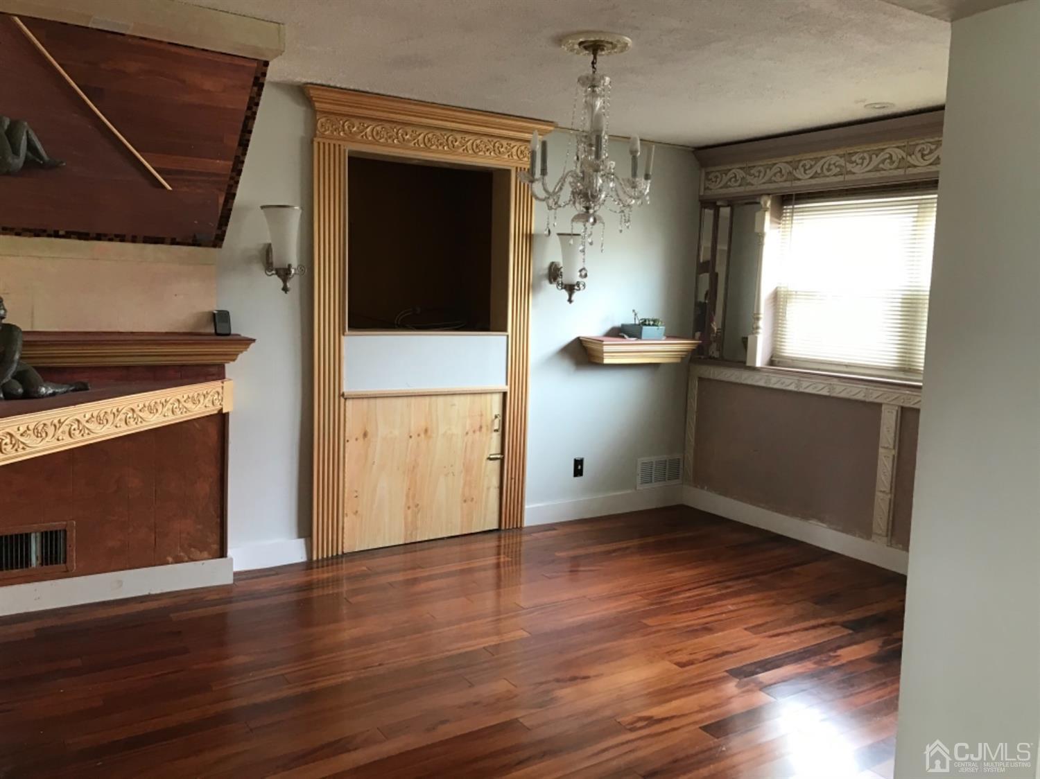 25 Wilshire Road Edison, NJ 08817 - Photo 4 of 18 a view of empty room with wooden floor and fireplace