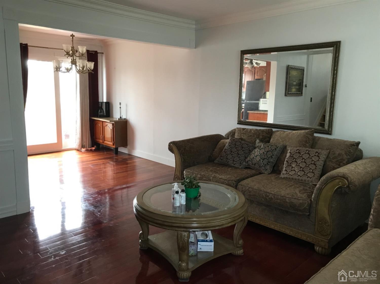 25 Wilshire Road Edison, NJ 08817 - Photo 7 of 18 a living room with couches and a dining table with wooden floor