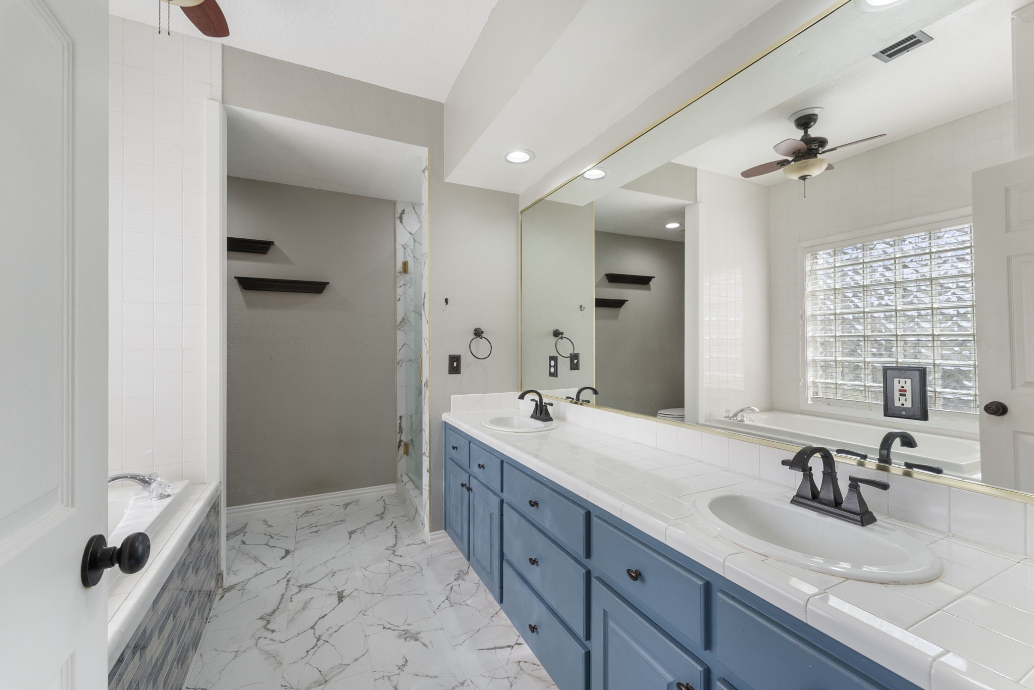 13942 Longstreet Road Willis, TX 77318 - Photo 13 of 46 a bathroom with a double vanity sink a mirror and a shower