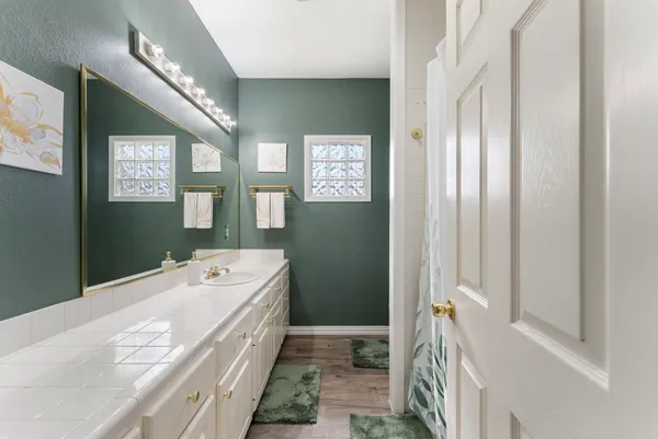 a spacious bathroom with a tub sink and mirror