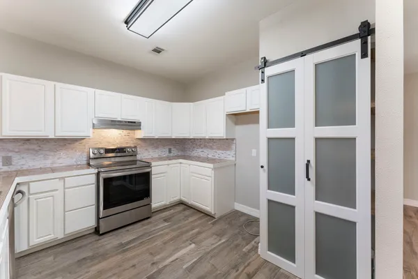 a kitchen with stainless steel appliances granite countertop a stove and a refrigerator