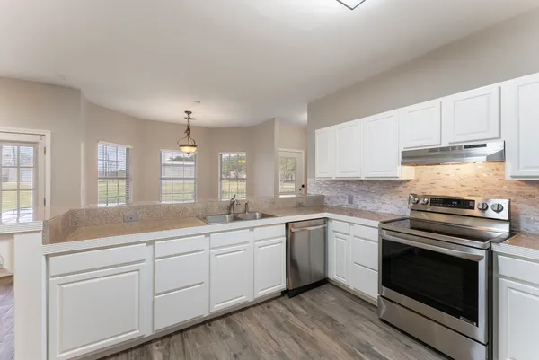 a kitchen with a sink stove and cabinets