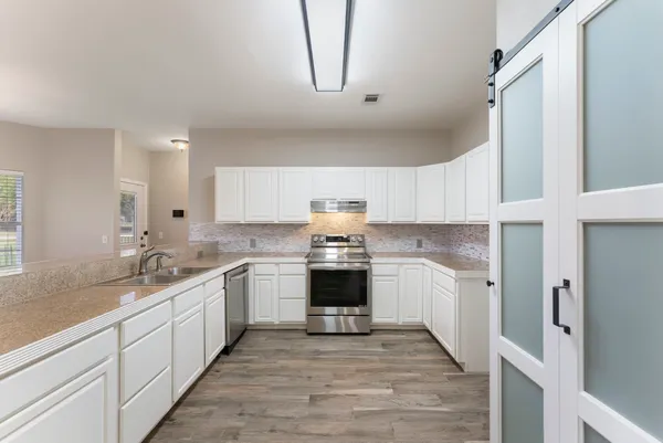 a kitchen with stainless steel appliances granite countertop a sink and cabinets
