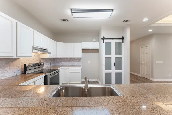 a kitchen with stainless steel appliances granite countertop a sink stove and refrigerator