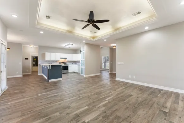 a view of kitchen with stainless steel appliances refrigerator stove and wooden floor