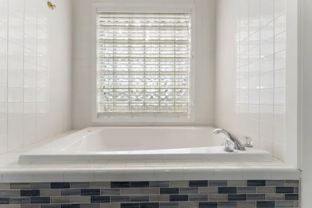 a spacious bathroom with a double vanity sink a mirror and shower
