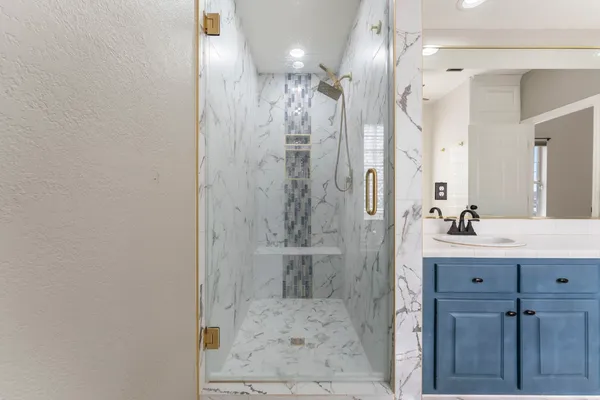 a bathroom with a glass shower door and a sink