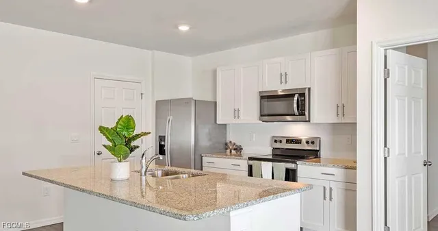 a kitchen with appliances a sink and a counter top space