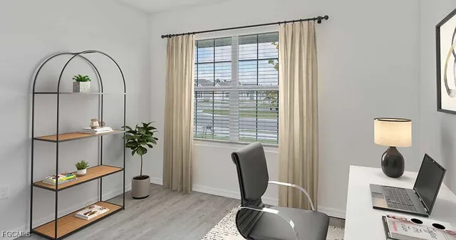 a view of a workspace with furniture and a window