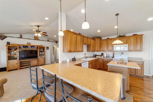 a large kitchen with cabinets a sink a counter space and stainless steel appliances