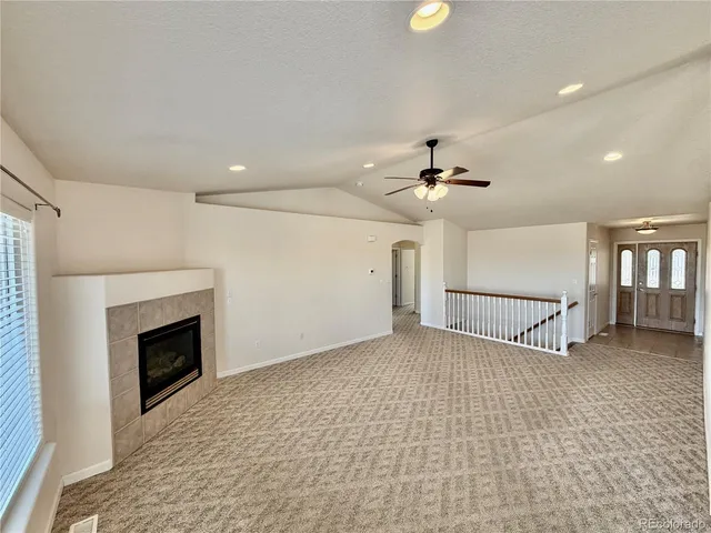 a view of a livingroom with a ceiling fan fireplace and window