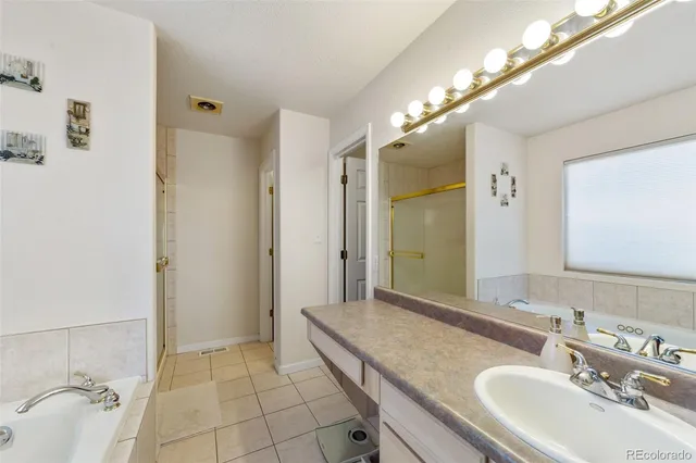 a bathroom with a granite countertop double vanity sink a mirror and a shower