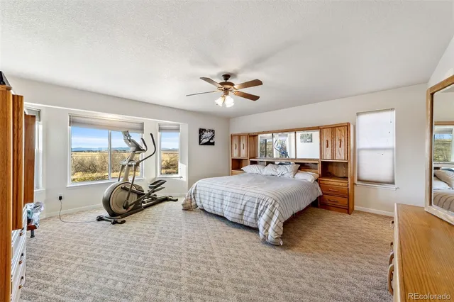 a bedroom with a bed and a large window