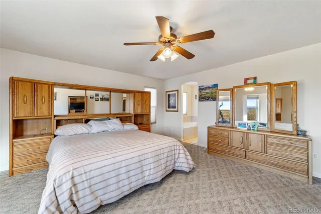 a spacious bedroom with a large bed and a chandelier