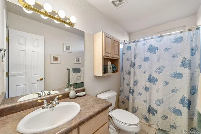 a bathroom with a granite countertop sink toilet a mirror a vanity and shower