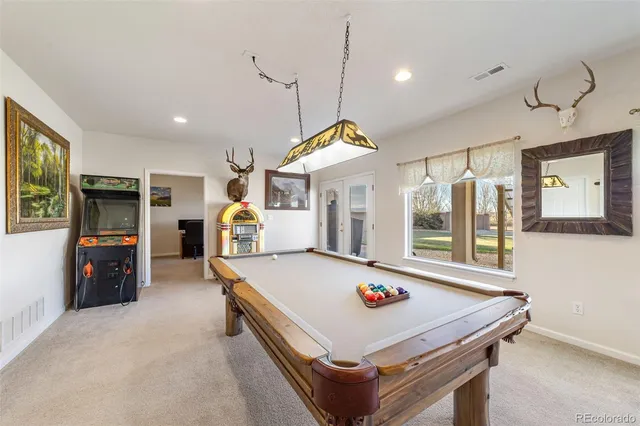 a room with pool table and windows