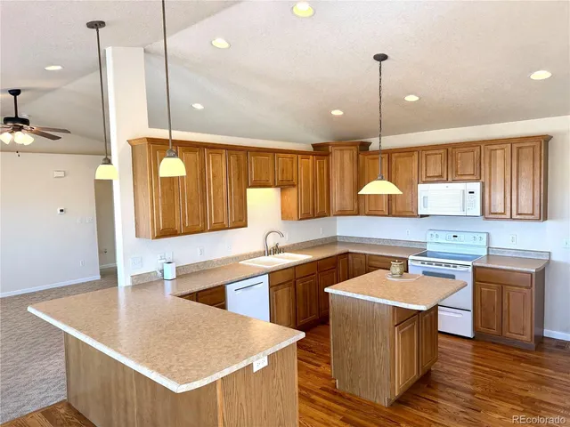a kitchen with kitchen island a sink appliances and a counter top space