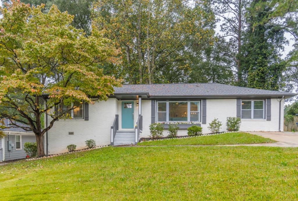2363 Cranbrooke Drive Decatur, GA 30032 - Photo 1 of 1 a front view of house with yard and trees in the background