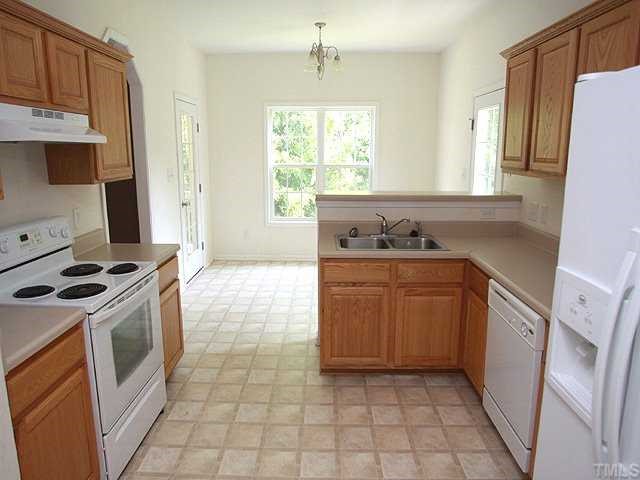 5821 Forest Point Road Raleigh, NC 27610 - Photo 5 of 12 a kitchen with a stove sink and cabinets
