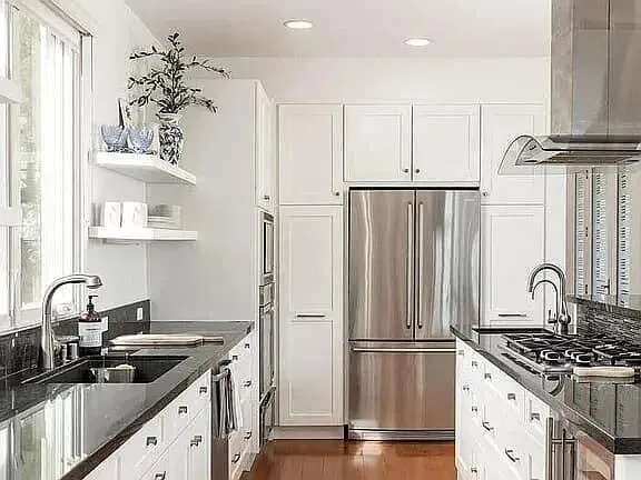 a kitchen with granite countertop a sink stainless steel appliances and cabinets