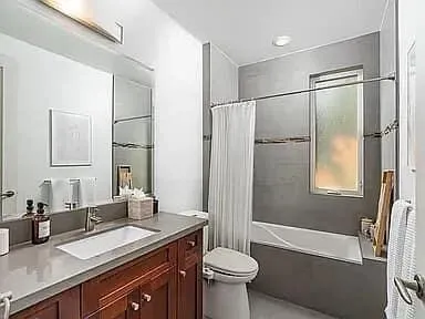 a bathroom with a granite countertop sink toilet and shower