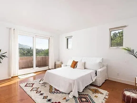 a bedroom with a bed and a large window