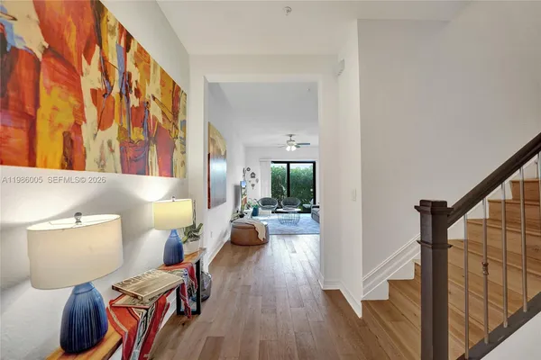 a view of a hallway with furniture and wooden floor