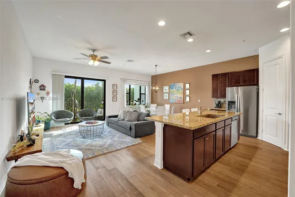 a open kitchen with stainless steel appliances granite countertop a lot of counter space and living room