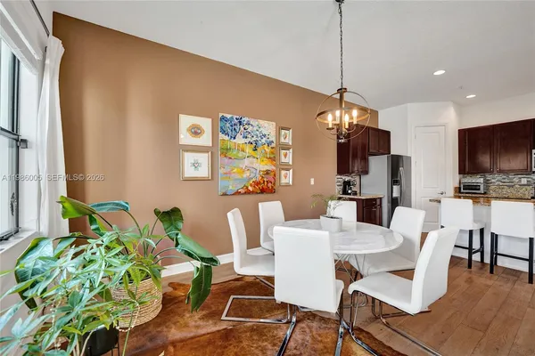 a view of a dining room with furniture a rug and wooden floor