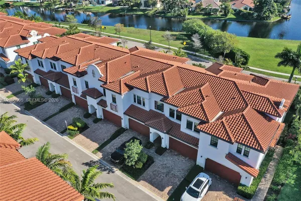an aerial view of house with yard and lake view in back