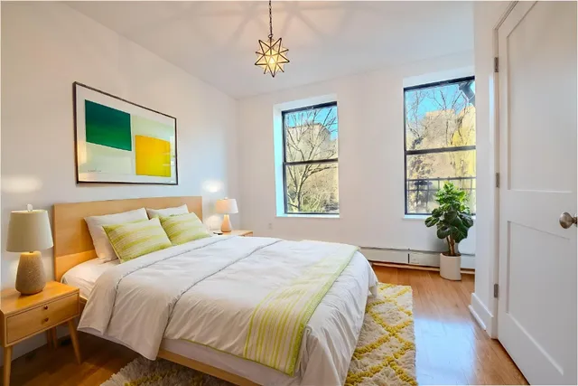 a spacious bedroom with a bed and a painting on the wall
