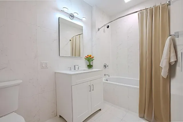 a bathroom with a sink a mirror a toilet and a shower