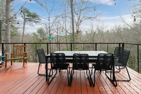 a view of a roof deck with table and chairs with wooden floor and fence