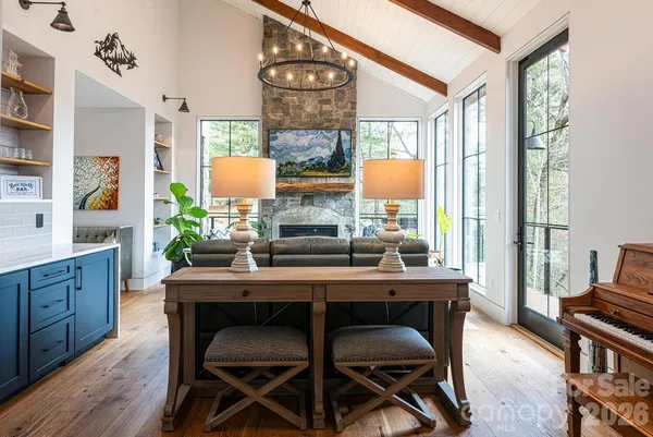 a dining room with furniture a large window and wooden floor