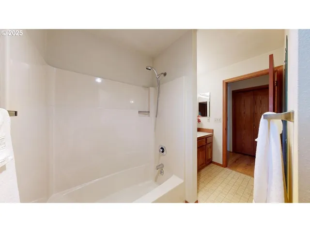 a bathroom with a tub shower and a sink