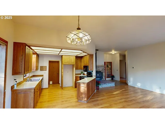 a kitchen with stainless steel appliances kitchen island granite countertop a sink refrigerator and cabinets