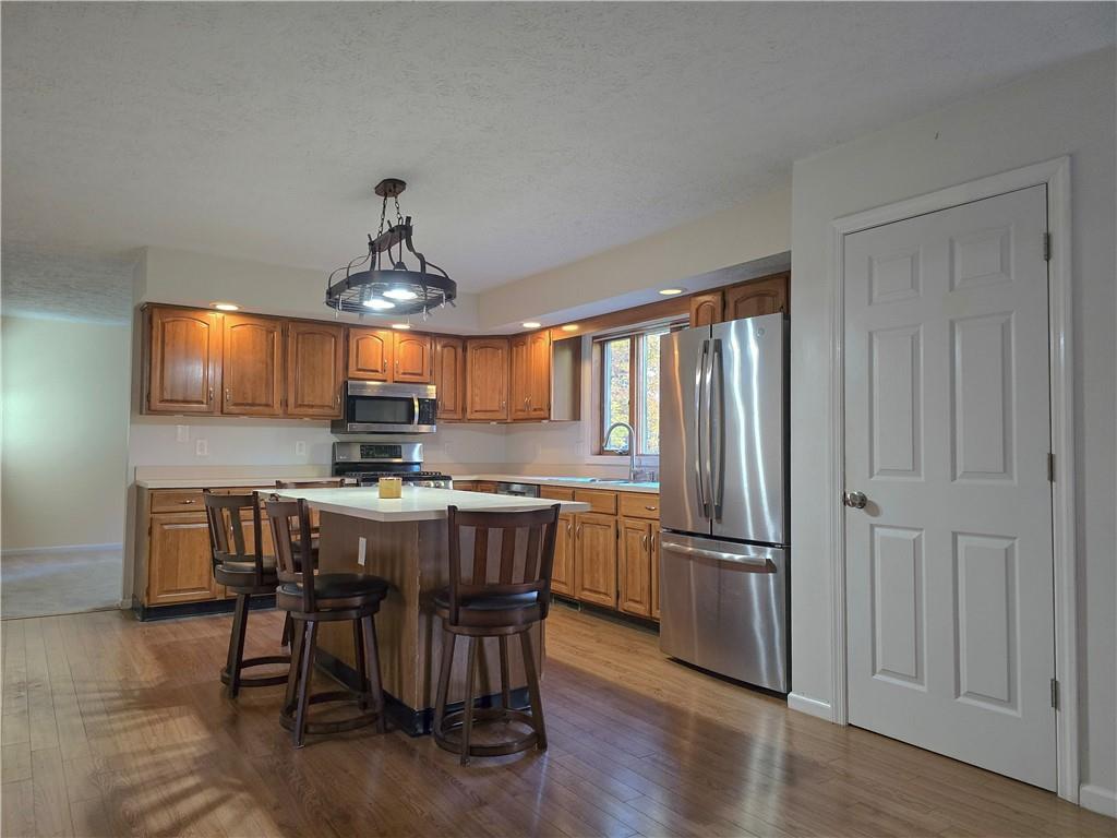 316 Stein Road Chicora, PA 16025 - Photo 11 of 41 a kitchen with stainless steel appliances a dining table chairs stove refrigerator and cabinets