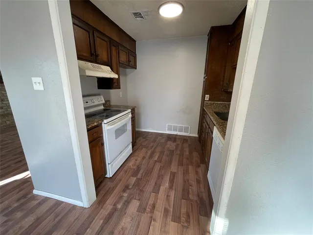 a kitchen with wooden floors and a sink