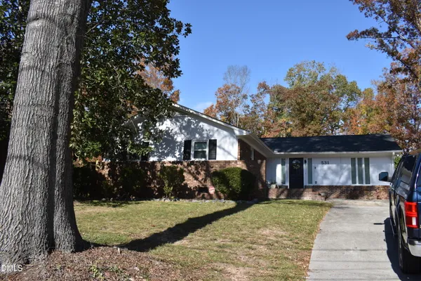 a front view of a house with a yard and trees