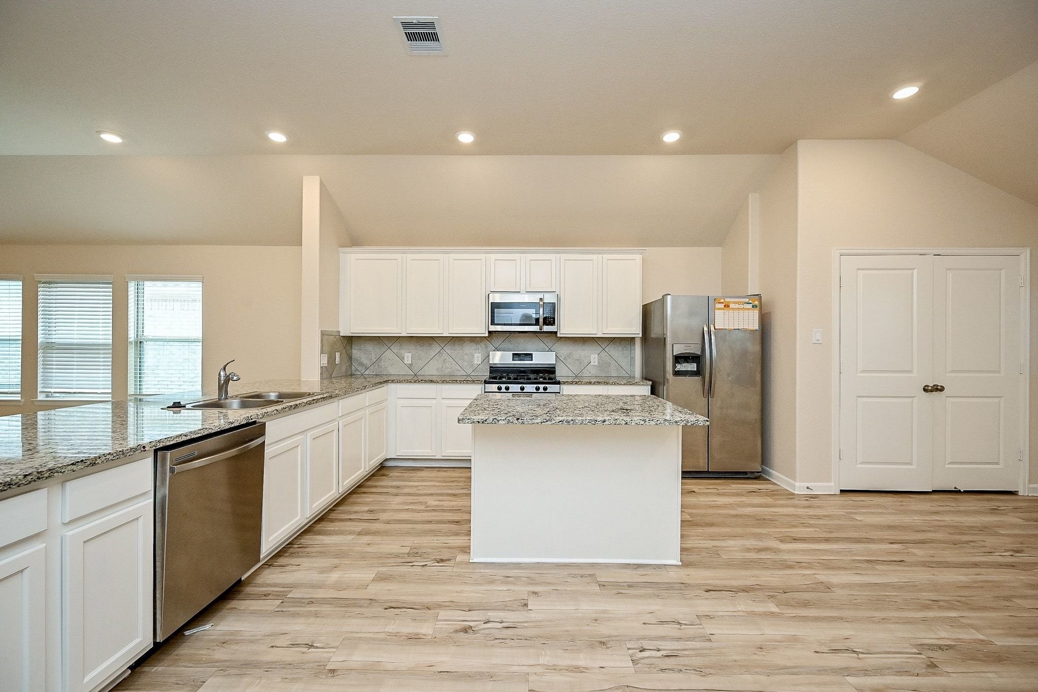 3715 Homestead Ridge Lane Richmond, TX 77406 - Photo 2 of 20 a large kitchen with stainless steel appliances a large counter top a stove and a refrigerator
