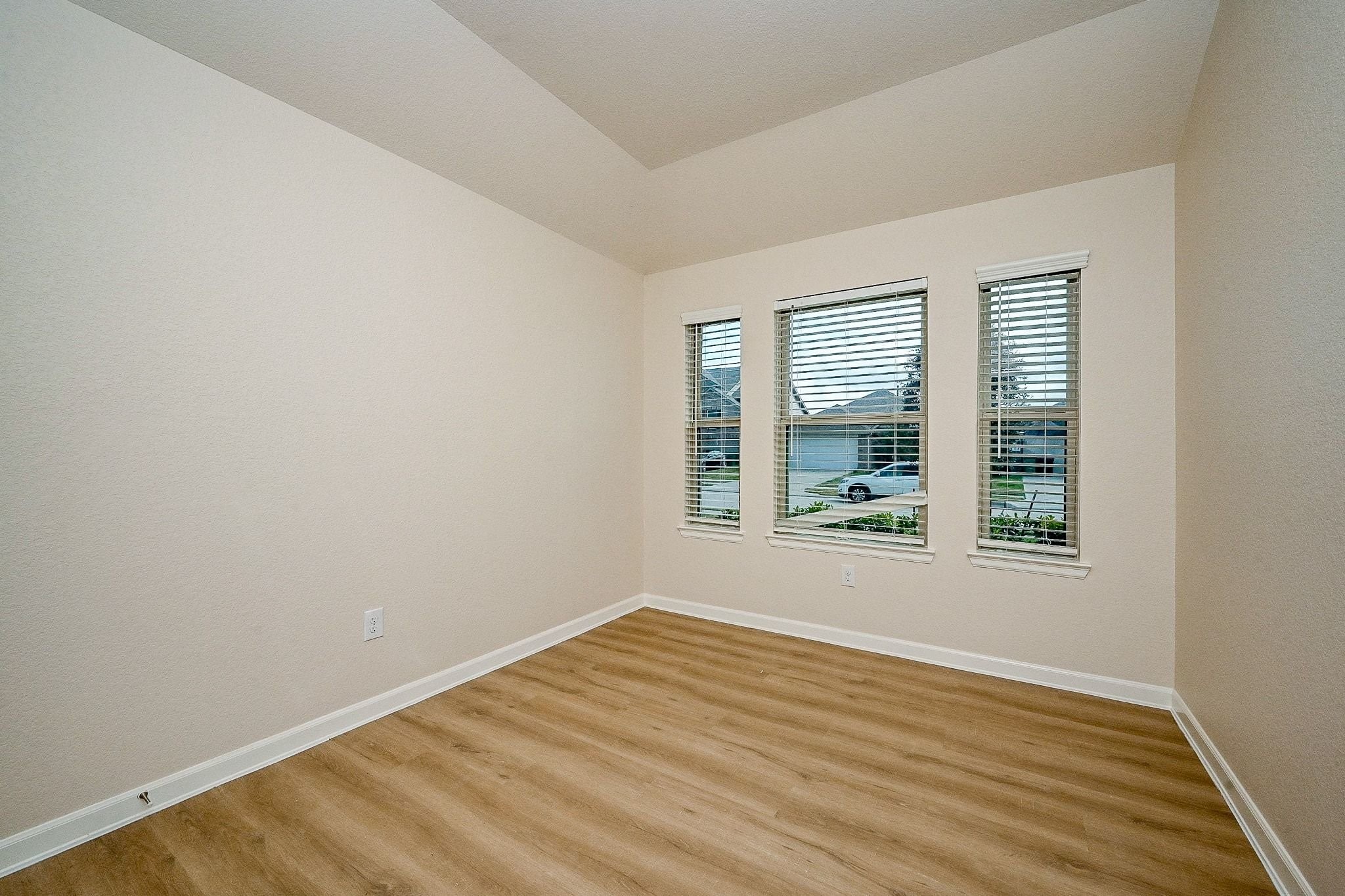 3715 Homestead Ridge Lane Richmond, TX 77406 - Photo 7 of 20 a view of an empty room with wooden floor and a window