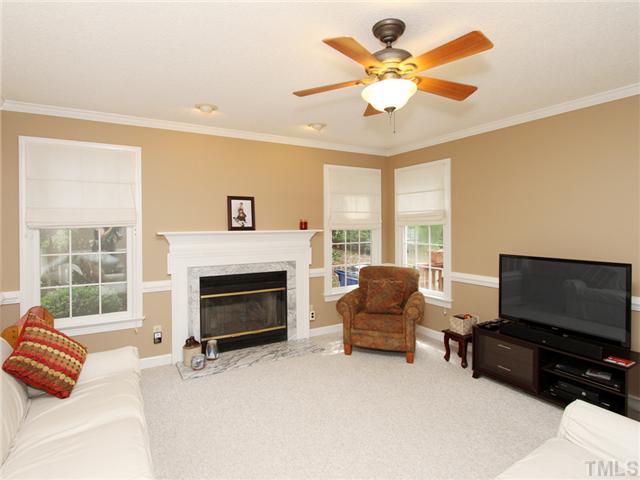 5629 Barham Court Raleigh, NC 27613 - Photo 7 of 17 a living room with furniture a fireplace and a flat screen tv