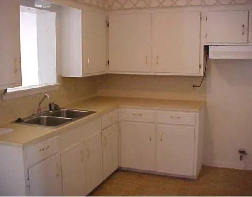 a kitchen with white cabinets and white appliances