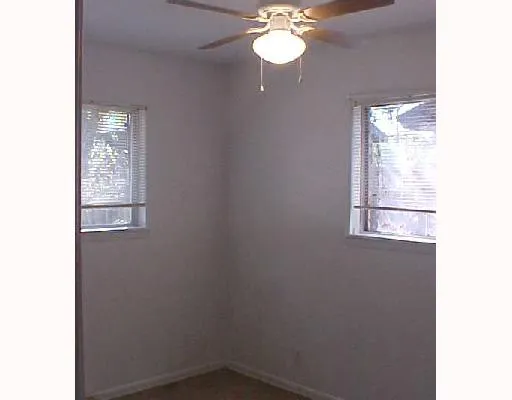 a view of a small space with wooden floor and a window