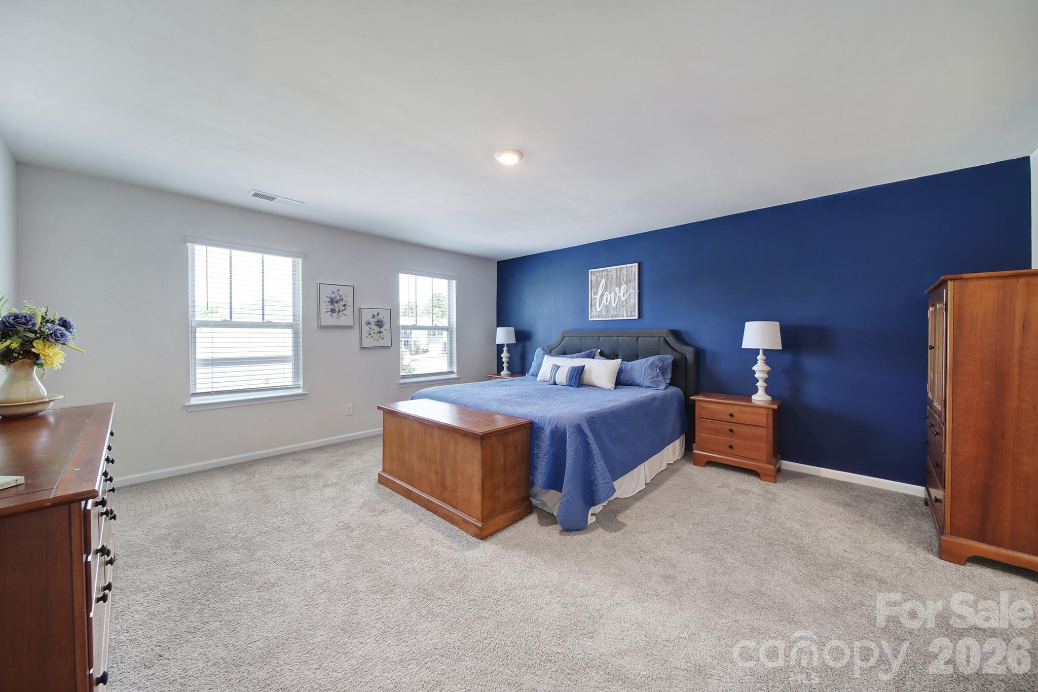 107 Spring Hall Court Troutman, NC 28166 - Photo 13 of 28 a spacious bedroom with a bed and a window